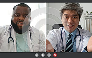 Screen application view of Asian senior doctor and African American wears white coat stethoscope on neck and video conference for