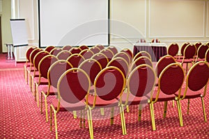 Screen and chairs in empty conference hall with a
