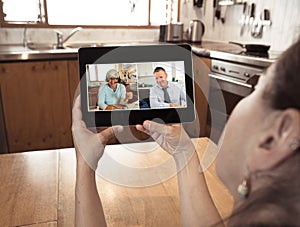 Screen tablet image of workers having a virtual meeting during coronavirus lockdown