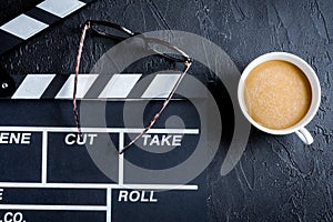 Screenwriter desktop with movie clapper board dark background to