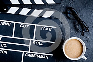 Screenwriter desktop with movie clapper board dark background to