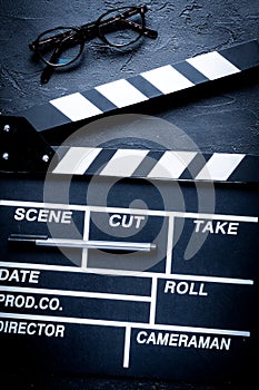 Screenwriter desktop with movie clapper board dark background to