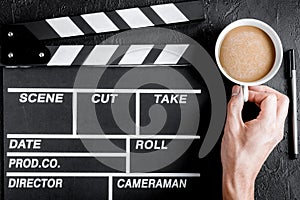 Screenwriter desktop with movie clapper board dark background to