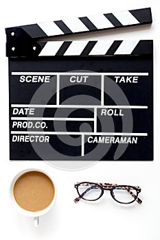 Screenwriter desktop with movie clapper board white background top view