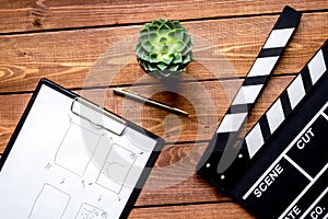 Screenwriter desktop with movie clapper board wooden background