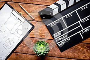 Screenwriter desktop with movie clapper board wooden background