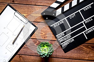 Screenwriter desktop with movie clapper board wooden background