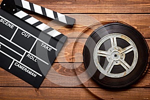 Screenwriter desktop with movie clapper board wooden background top view