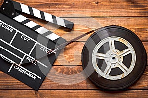 Screenwriter desktop with movie clapper board wooden background top view