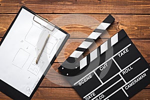 Screenwriter desktop with movie clapper board wooden background top view photo