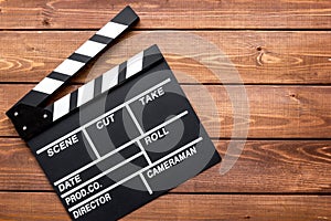 Screenwriter desktop with movie clapper board wooden background top view