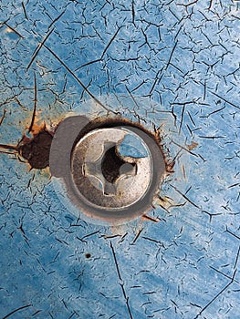 Screw on a Cracked and mottled paint wall