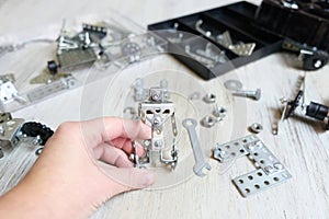 Screw driver, nuts, wrench, bolts and parts of children`s metallic constructor. children`s metal kit. homeschooling