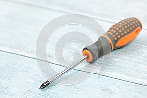 Screwdriver on the blue wooden planks background with copy space