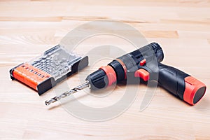 Screwdriver and drill. The drill drills a wooden block. Carpenter\'s workshop