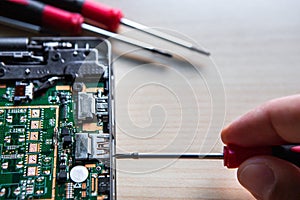 A screwdriver in the hand of a server disassembling a computer. The computer is broken and he hopes to fix it. Copy space