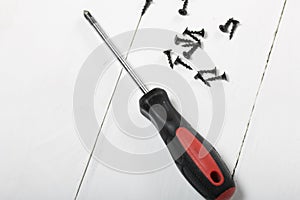 A screwdriver and a handful of screws. On white background