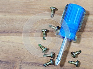 screwdriver and screwS on wood background