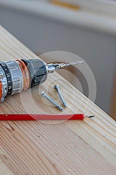 screwdriver, two confirmations and a pencil on the board photo