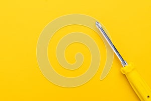 Screwdriver on yellow background