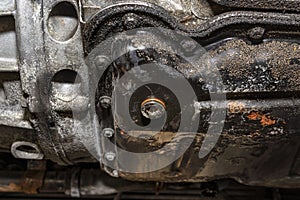 Screwed bolt at the bottom of the oil pan of a diesel engine with a new, copper washer, after pouring out old oil.