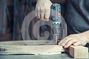 Screwing wooden furniture in a joinery using an electric drill bit