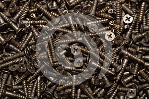 Screws background. heap of tapping screws. pile of fasteners