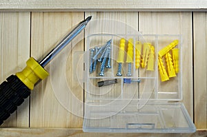 Screws, dowels and screwdriver lie on the boards