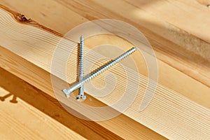The screws lie on a wooden board