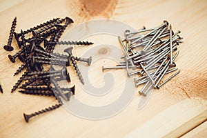 Screws, nails, bolts srt on the wooden table photo