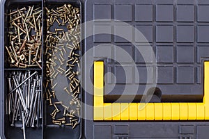 Screws and nails in plastic box close up.