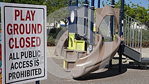 Scribbled notes of protest on a closed playground sign during Covid-19 shutdown.