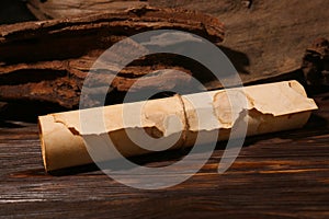 Scroll of old parchment paper on wooden table