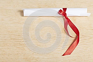 Scroll of paper with a red ribbon.