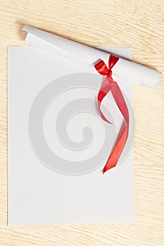 Scroll of paper with a red ribbon.