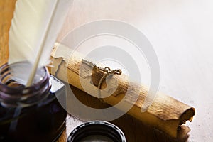 Scroll and quill pen on wooden table