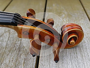 Scroll of violin placed on wooden bench