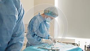 Scrub nurse preparing medical instruments for operation. Close-up Shot in Operating Room of Surgical Table with