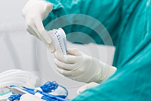 Scrub nurse preparing tools for operation