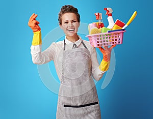 Scrubwoman with a basket with cleansers and brushes