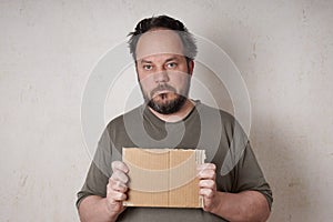 Scruffy man holding sign