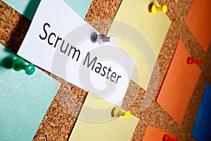 Scrum master is written on a piece of paper which on a bun is attached to a board photo