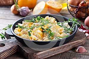 Scrumble eggs with corn, cheese and arugula on a table. Delicious breakfast