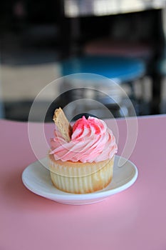 Scrumptious coconut cupcake with cherry frosting