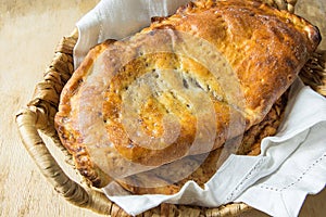 Scrumptious Home Baked Italian Pastry Calzone with Sweet Apple Pie Raisins Cinnamon Filling in Wicker Basket on White Linen Napkin