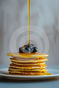 Scrumptious stack of pancakes topped with fresh berries and a delightful drizzle of honey on a plate photo