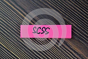 SCSS write on sticky notes isolated on Wooden Table