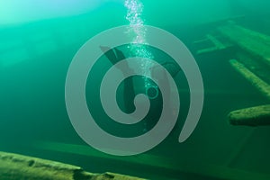 SCUBA diver entering the cabin trunk of wooden schooner shipwreck