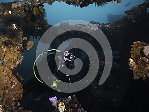 A scuba diver exploring a deep ship wreck underwater