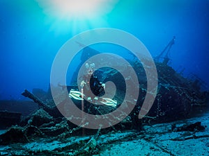 Scuba diver in front of a sunken shipwreck
